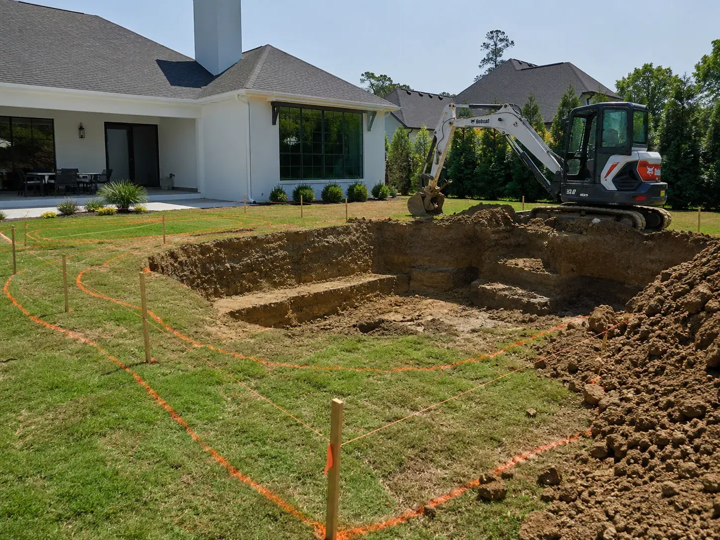 Excavator digging pool shell in Tulsa backyard